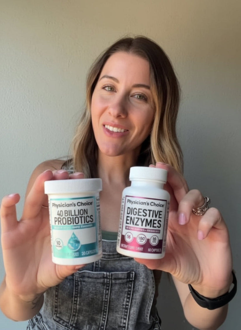 Woman holding two supplement containers labeled 'Probiotic' and 'Digestive Enzymes' against a plain background.